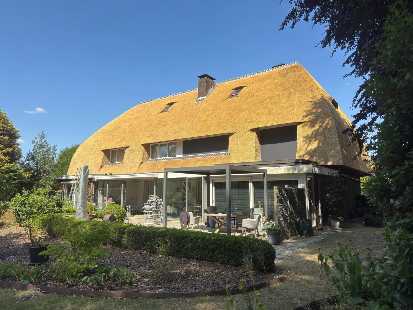 Nieuw rieten dak op een woonhuis met serre