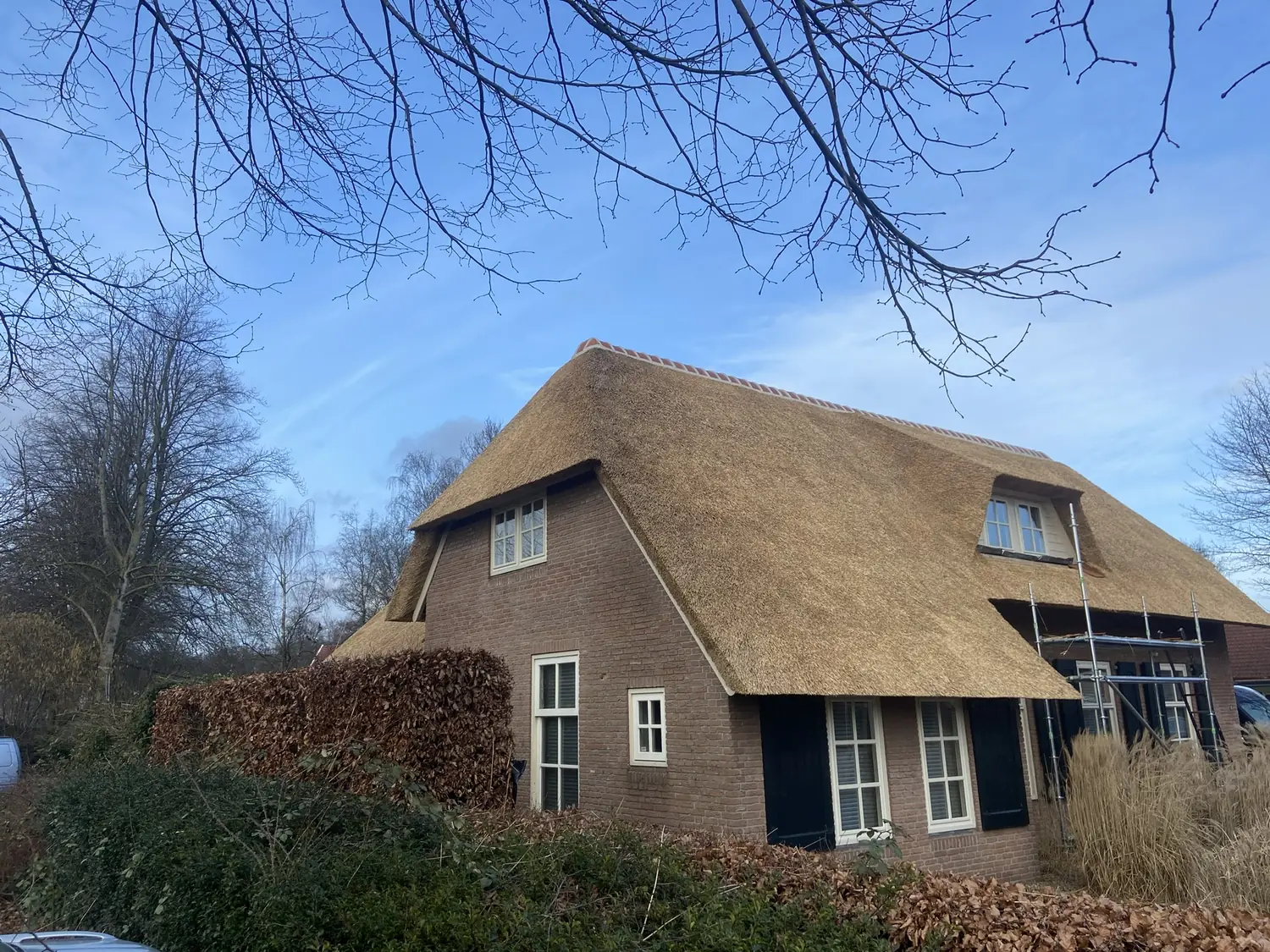 Boerderij met een nieuw rieten dak, gezien vanaf de tuinzijde