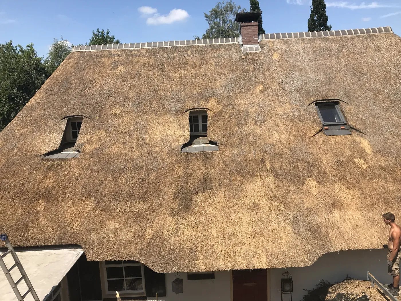 Rieten dak met drie dakkapellen tijdens renovatie en verdikken